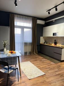 una cucina e un soggiorno con tavolo e cucina di Квартира в Грин Плазе ad Aqtau