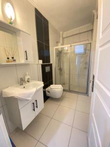 a white bathroom with a sink and a toilet at KAŞ MERKEZ İMREN APART 1 in Kas