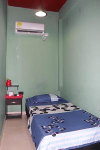 um quarto com uma cama e ar condicionado em RIO Colors - Hospedaje em Barrancabermeja