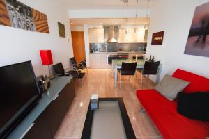 a living room with a red couch and a table at Salicornia apartament in L'Eucaliptus