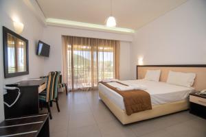a hotel room with a bed and a desk and a bedroom at Riviera Perdika Hotel in Perdika