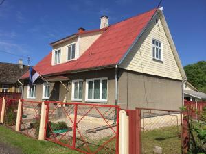 ein Haus mit rotem Dach und einem Zaun in der Unterkunft Angelhouse studio in Tartu