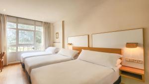 ペリリョにあるHotel Faranda Rías Altasのベッド2台と窓が備わるホテルルームです。