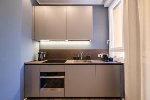 ボローニャにあるBlue Suite by Studio Vitaの白いキャビネット、シンク、窓付きのキッチン