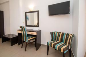 a room with a desk and two chairs and a mirror at Riviera Perdika Hotel in Perdika
