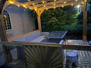 a pergola with a grill on a deck with lights at Willow Lodge , Corskie Drive Macduff-Banff in Macduff