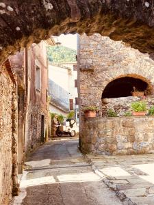 um beco com um arco num antigo edifício de pedra em La Cantina Del Sole em Riccò del Golfo di Spezia