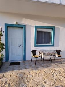 een patio met 2 stoelen en een tafel naast een deur bij Studio un nid in Douliana