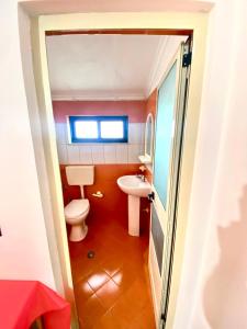 a small bathroom with a toilet and a sink at Villa Osmani in Durrës