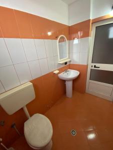 La salle de bains est pourvue de toilettes et d'un lavabo. dans l'établissement Villa Osmani, à Durrës