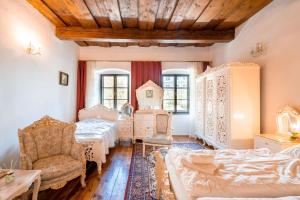 a bedroom with two beds and a couch and a chair at Leylaria in Český Krumlov