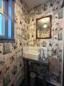 a bathroom with a sink and a mirror at Zen House By The Sea In Margate in Kent