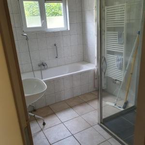 een badkamer met een bad en een wastafel bij Vinkie in De Waal