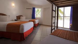 Habitación de hotel con 2 camas y ventana en Vista Playa de Oro Manzanillo, en Manzanillo