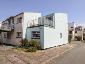 a white building with a balcony on the side of it at 1 South Snowdon Wharf in Porthmadog