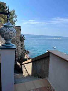 a blue and white vase on a wall next to the ocean at Il Sogno in Erchie