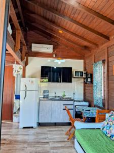 因比圖巴的住宿－Chalés Praia do Rosa piscina compartilhada，厨房配有白色冰箱和桌子