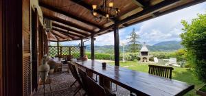 a large wooden table on a patio with a view of a yard at Villa Monica, barbecue, spa, piscina in Terni