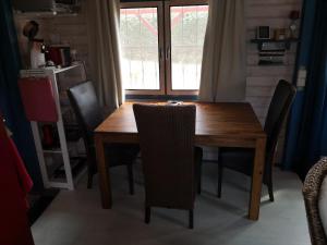 a wooden dining room table with chairs and a window at Rotes Haus Usedom in Kamminke