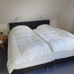 een bed met twee witte kussens erop bij Vinkie in De Waal