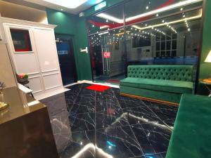 a room with a green couch and a table at 1 Day Car Hotel - BG Perdana in Batu Gajah +20 photos