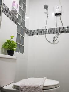 a bathroom with a shower with a toilet and a plant at NK Guesthouse 1 in Khlong Toei