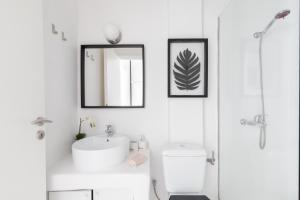 a white bathroom with a sink and a mirror at Sandy's House-Mykonos Town by Dival Properties in Mýkonos City +17 photos
