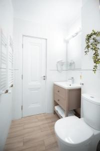 a white bathroom with a toilet and a sink at Studio Vladut in Saturn