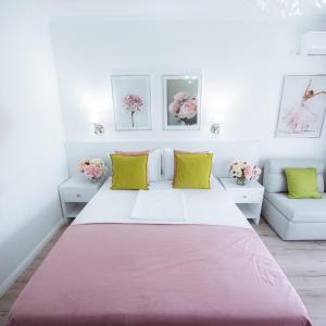 a white bedroom with a large bed and two couches at Studio Vladut in Saturn