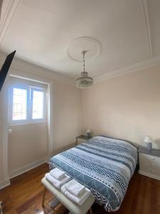 1 dormitorio con 1 cama con manta azul y ventana en Angels Homes-n27, 3ºfloor - Bairro Típico, Centro Lisboa en Lisboa