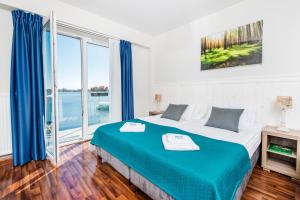 une chambre avec un grand lit et une grande fenêtre dans l'établissement Ach Mazury, à Mikołajki