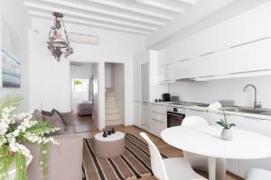 a white kitchen with a white table and chairs at Sandy's House-Mykonos Town by Dival Properties in Mýkonos City