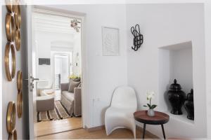a white living room with a white chair and a table at Sandy's House-Mykonos Town by Dival Properties in Mýkonos City