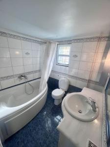 ein Badezimmer mit einem Waschbecken, einer Badewanne und einem WC in der Unterkunft Κυδωνιά Μάνη in Vathy