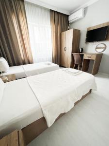 um quarto de hotel com duas camas e uma televisão em Karhal Hotel em Edirne