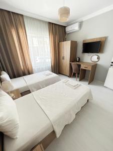 um quarto de hotel com duas camas e uma televisão em Karhal Hotel em Edirne