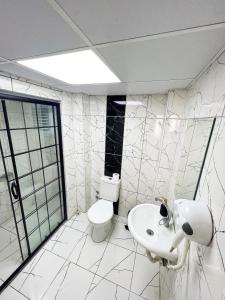 a white bathroom with a toilet and a sink at Karhal Hotel in Edirne