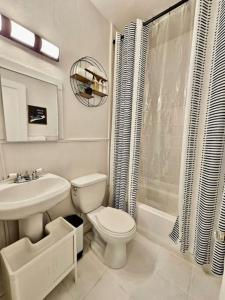 a white bathroom with a toilet and a sink at Cute stay in Memphis in Memphis