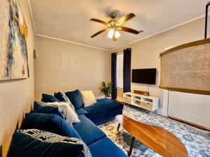 een woonkamer met een blauwe bank en een plafondventilator bij Cute stay in Memphis in Memphis