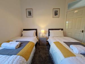 two beds sitting next to each other in a bedroom at Swanley Guest House in Kent
