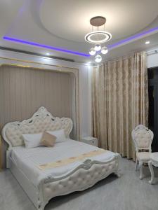 a bedroom with a large white bed and a chandelier at Khach sạn Starfish Tuy Hoà in Tuy Hoa