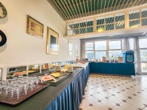 un ristorante con un lungo bancone con cibo sopra di Hotel Faranda Rías Altas a Perillo