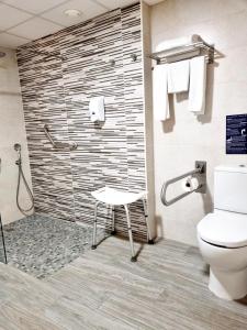 a bathroom with a shower with a toilet and a stool at Hotel Xaine Park in Lloret de Mar