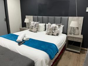 sypialnia z dużym łóżkiem i niebieskim kocem w obiekcie Empire Bed & Breakfast w mieście Leribe