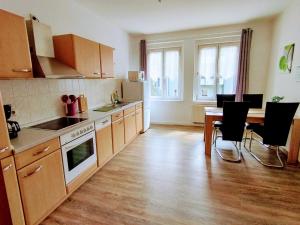 a kitchen with wooden floors and a table and chairs at Ferienwohnungen Schneider in Görlitz