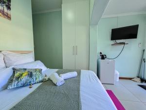 a bedroom with a bed with two towels on it at H G Deluxe Guest suites in East London