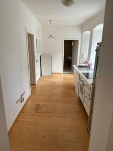 a kitchen with a wooden floor and a white refrigerator at Central Plaza family apartment 2 bedroom in Bruckneudorf
