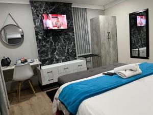 1 dormitorio con 1 cama y TV en la pared en Empire Bed & Breakfast en Leribe