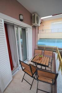 a patio with a table and chairs on a balcony at Little Cozy Apartment 1 in Sarandë