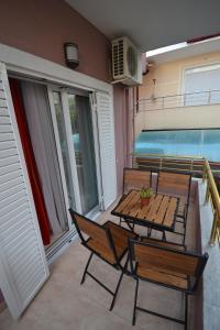 a patio with a table and chairs on a balcony at Little Cozy Apartment 1 in Sarandë